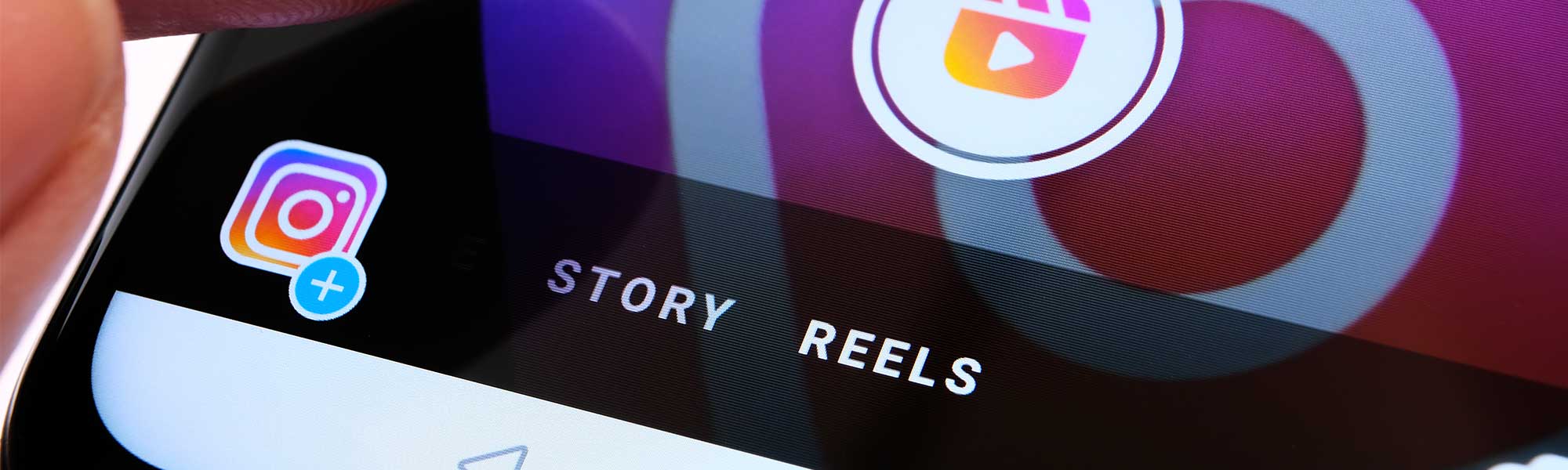 Close up of a smartphone screen with the Instagram logo and words "Story" and "Reels"