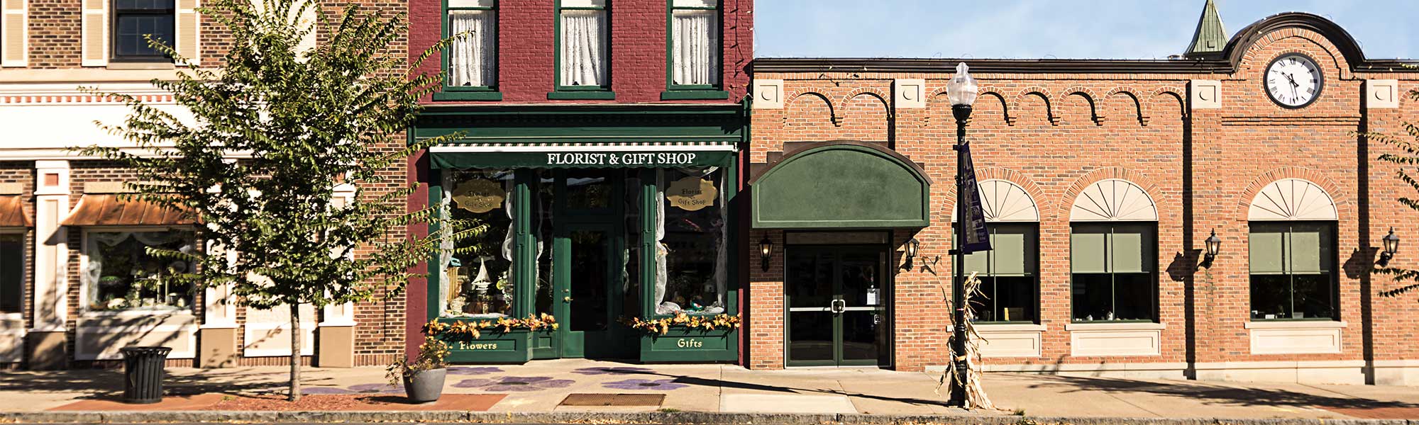 Street view of a Florist & Gift shop, next to two other buildings in a rural part of downtown.