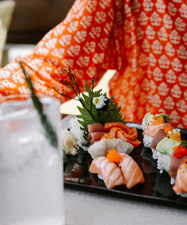 woman in bright shirt sitting over sushi
