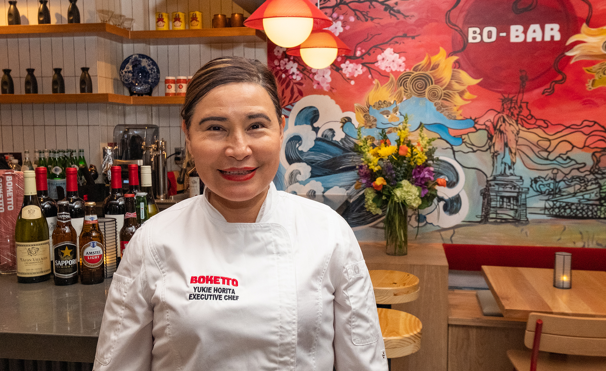 smiling woman in chef's jacket in bright restaurant