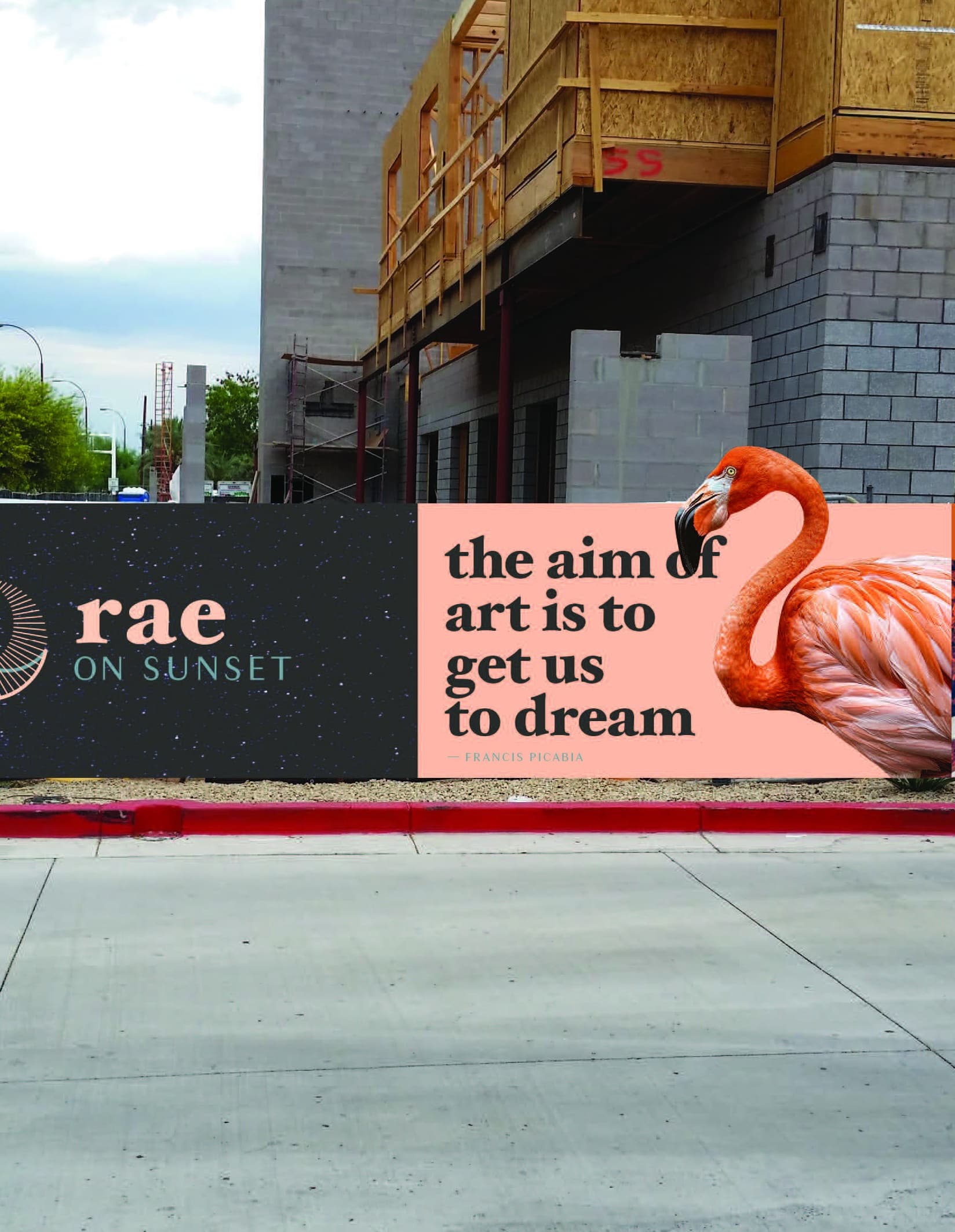 A construction billboard with a pink flamingo on it, with text that reads: "The aim of art is to get us to dream."